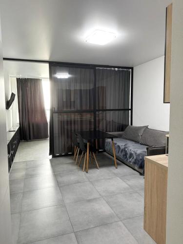 a living room with a bed and a table at Олімпік парк, м Бориспільська 5 хв пішки, генератор на будинку in Kyiv