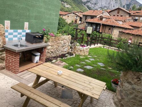 a backyard with a wooden picnic table and a garden at La Casuca ONE De Lebeña in Lebena