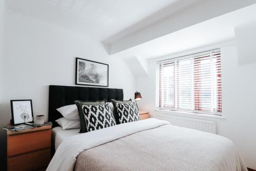 a bedroom with a large bed and a window at The Coachhouse by Solace Stays in Bassaleg