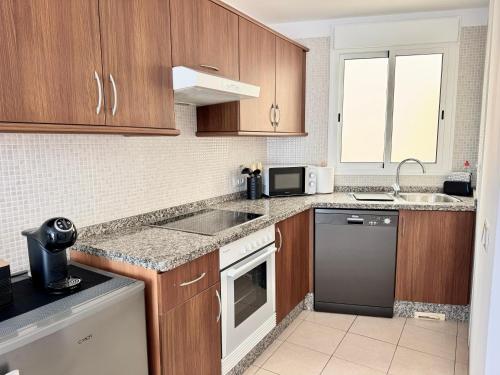 a kitchen with wooden cabinets and a sink at Poseidon Dreams Tenerife in Puerto de Santiago