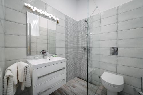 La salle de bains est pourvue de toilettes, d'un lavabo et d'une douche. dans l'établissement Fészek -Étel és Hotel-, à Zánka