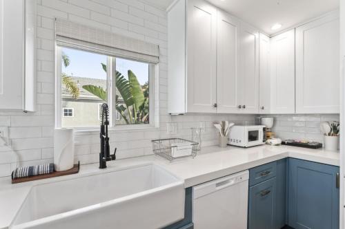 una cucina bianca con lavandino e finestra di Steps to Lido Village and the Marina Heart of Lido Island 2 Car Garage a Newport Beach