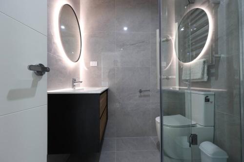 un bagno con doccia, WC e lavandino di Cozy 2 Bedroom Waterview Home for Work and Family ad Auckland