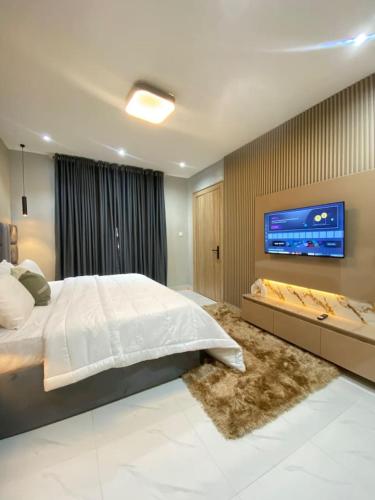 um quarto com uma cama grande e uma TV de tela plana em 1 Bedroom Apt Sabolak Suite Sapphire em Ikate
