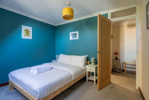 Chestertonにある1Bed Central Apt With Parkingの青い壁のベッドルーム1室(大型ベッド1台付)
