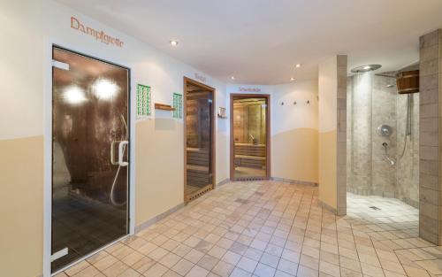 y baño con ducha y cabina de ducha a ras de suelo. en Saldur Small Active Hotel, en Sluderno