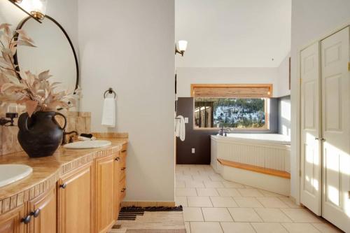 a bathroom with a tub and a sink and a mirror at New. Top of the World Lodge. Hot tub. Theater. in Evergreen