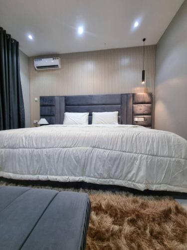 a bedroom with a large white bed with a rug at 1 Bedroom Apt Sabolak Suite Haven in Ikate