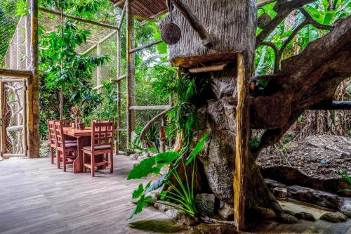 a dining room with a table and a tree at Casa Aviari in Cabo Matapalo