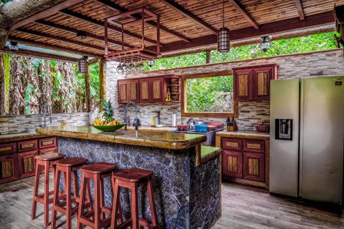a kitchen with a large stone counter with stools at Casa Aviari in Cabo Matapalo