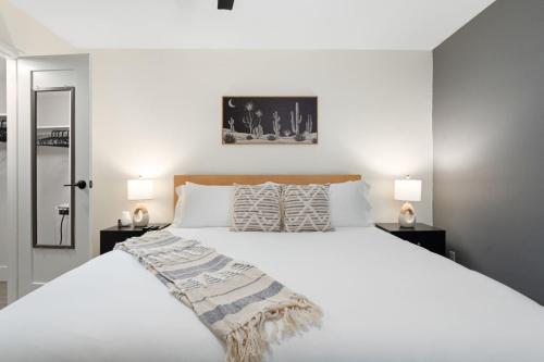 a bedroom with a large white bed with two lamps at Walk to Old Town - 1BR Condo, Heated Pool and Patio in Scottsdale