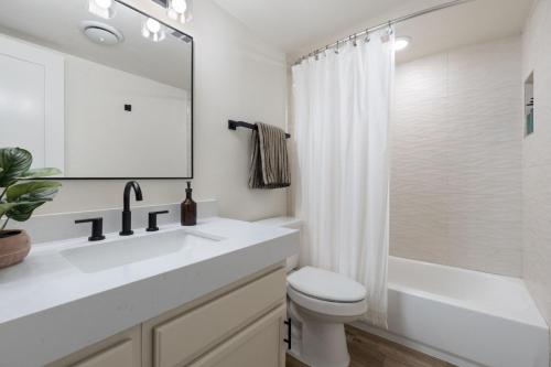 a white bathroom with a sink and a toilet at Walk to Old Town - 1BR Condo, Heated Pool and Patio in Scottsdale
