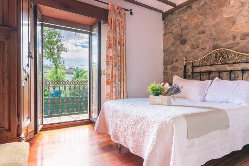 une chambre avec un lit et une grande fenêtre dans l'établissement Casa Rural La Venta, à Iruz