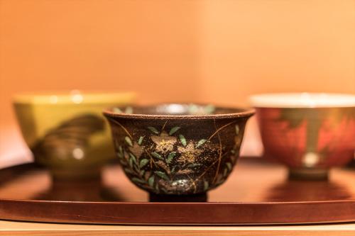 a tray with three cups on a table at Villa Sanjomuromachi KYOTO in Kyoto