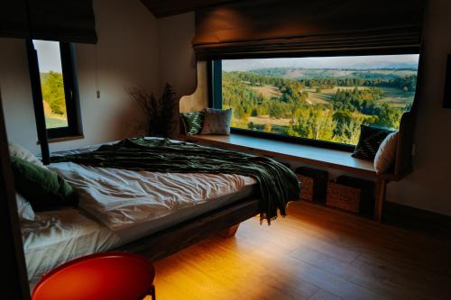 a bedroom with a bed and a large window at Aftăr Hills in Poiana Mărului