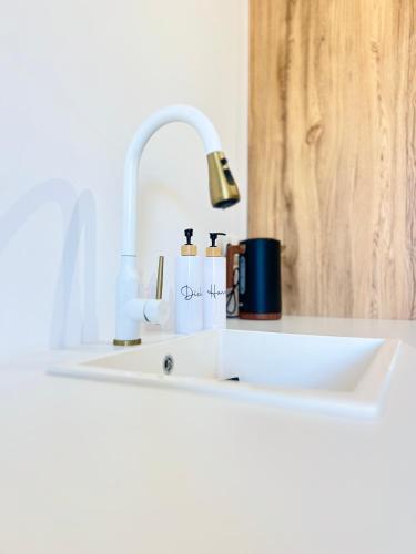 a kitchen sink with a faucet and cups on it at Koselig Lodge in Pídhasos