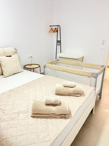 a bedroom with a large bed with towels on it at Koselig Lodge in Pídhasos