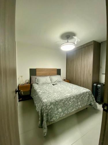 a bedroom with a bed and a light on the ceiling at New modern apartment in Barranquilla