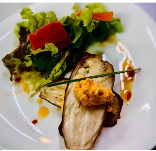 a white plate of food with a salad on it at Logis hôtel l'instant Mont le Viaur in Saint-André-de-Najac