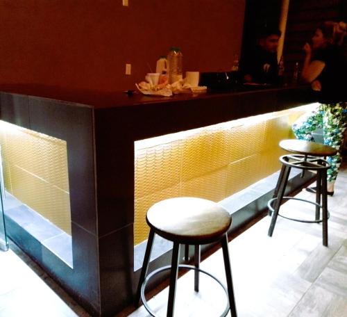a bar with two stools in front of a counter at A02 SUITE BLACK para 1 a 3 personas, CORTAS, MEDIANAS Y LARGAS ESTANCIAS en IZCALLI TEPOTZOTLAN, Facturamos! in Cuautitlán Izcalli