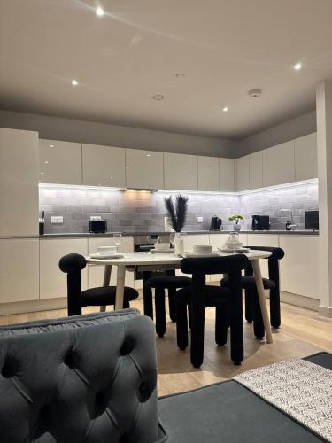 a dining room with tables and chairs in a kitchen at Luxury 2 Bedroom 2 Bathroom Apartment by ExCeL & The 02, London in London
