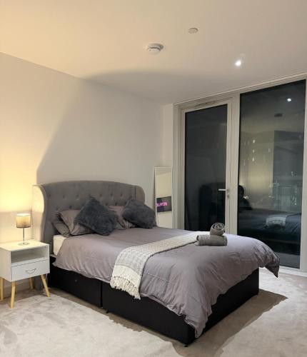 a bedroom with a bed and a large window at Luxury 2 Bedroom 2 Bathroom Apartment by ExCeL & The 02, London in London