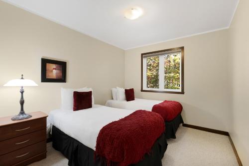 a bedroom with two beds and a window at Borealis by Rendez-Vous Mont-Tremblant in Mont-Tremblant