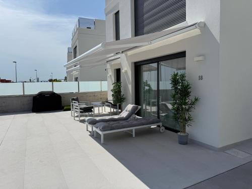 eine Terrasse mit 2 Stühlen und einem Tisch auf einem Gebäude in der Unterkunft Villa Mirasol - mountain-, sea view, roof terrace, private pool in Mutxamel