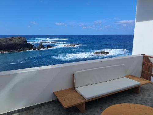 a bench in a room with a view of the ocean at Sinagoga Guesthouse in Ribeira Grande