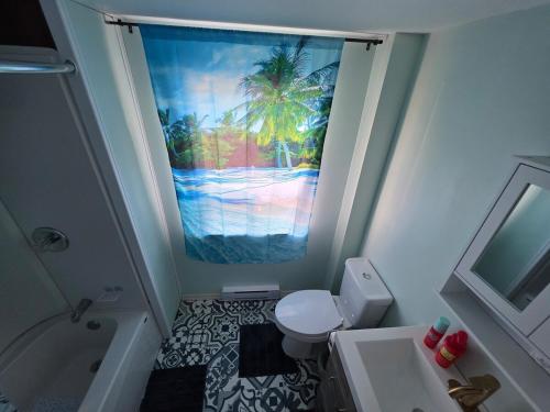 Un baño con un cuadro de una palmera. en Cozy 2-bedroom Downtown Apartment Campbellton Walk to Cafés & Shops, en Campbellton