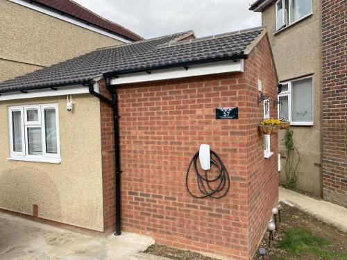 a brick building with a hose attached to it at Modern, Brand-new Detached House in Oxford