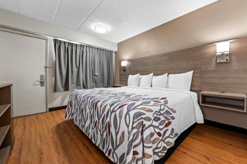 a hotel room with a large bed and a window at Red Roof Inn Columbus West - Hilliard in New Rome