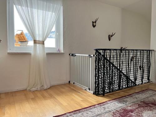 グレーンにあるHaus Capellaのカーテンと門が付いた窓のある部屋