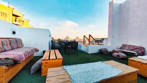 a balcony with a couch and a table on a building at Hostalio Pyramid View in Cairo