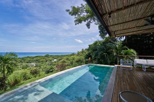 ein Swimmingpool mit Blick auf das Meer in der Unterkunft SELVA RESORT Ocean View Luxury Villas in Playa Santa Teresa
