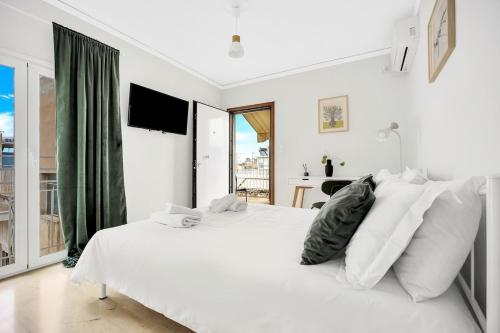 a white bedroom with a large white bed with white pillows at Athens sky & Acropolis view rooftop apartment! in Athens