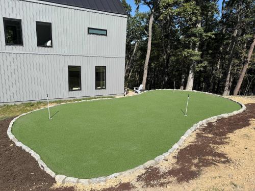 a putting green in front of a building at Modern Family Cabin 1 min to Bryce Fire Pit KING Bed in Basye