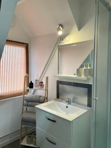 a bathroom with a sink and a mirror and stairs at Alsace in Beauvais