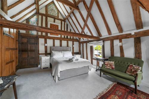 Un dormitorio con una cama y una silla verde. en Tallow Factory in Dedham, en Dedham