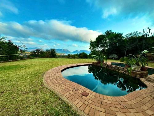 una pasarela de ladrillo alrededor de una piscina en un patio en Anahata Nature Resort, en Hartbeespoort
