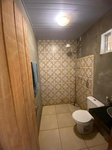 a bathroom with a toilet and a sink at Quintal da prainha Bar - pousada simples-beira da lagoa in Santana do Riacho