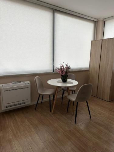a room with a table with chairs and a vase of flowers at Air B&B Hotel in Rrëshen