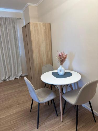 a table with chairs and a vase of flowers on it at Air B&B Hotel in Rrëshen