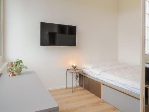 a bed in a room with a tv on the wall at WYBA Living, stilvoll&zentral in St Gallen -6min zur Olma Messe in St. Gallen