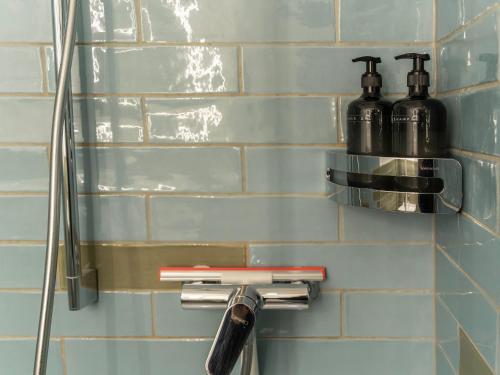 a bathroom with two soap dispensers on a wall at WYBA Living, stilvoll&zentral in St Gallen -6min zur Olma Messe in St. Gallen