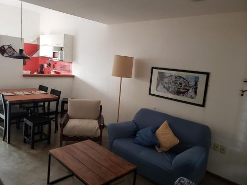 a living room with a blue couch and a table at Casa patio y parrillero in Montevideo