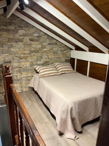 a bedroom with a bed and a stone wall at Descanso,verde,paz in Mar del Plata