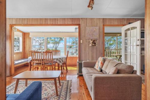a living room with a couch and a table at Rowse House Hyams Beach in Hyams Beach