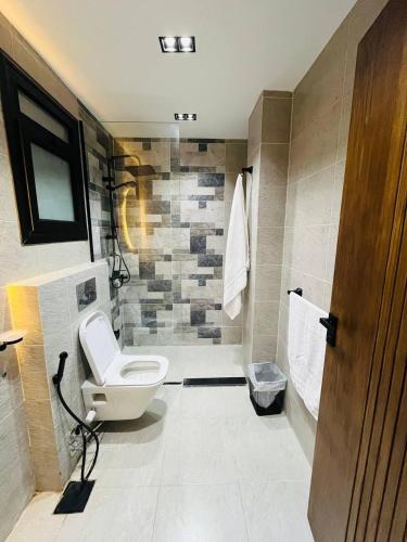 a bathroom with a toilet and a shower at كمبوند الكناريا عماره 81 in Sheikh Zayed
