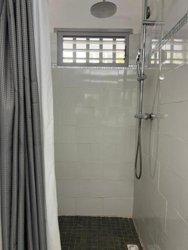 a shower with a shower curtain in a bathroom at Sunset View & Ocean Breeze in Cul de Sac